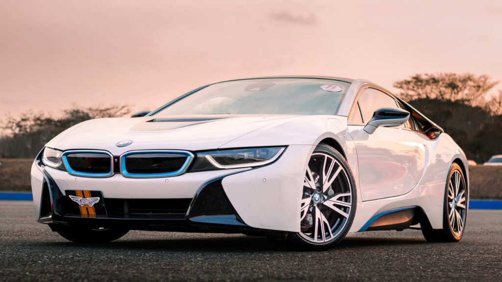 A sleek white luxury car photographed at sunset, highlighting modern design and elegance.