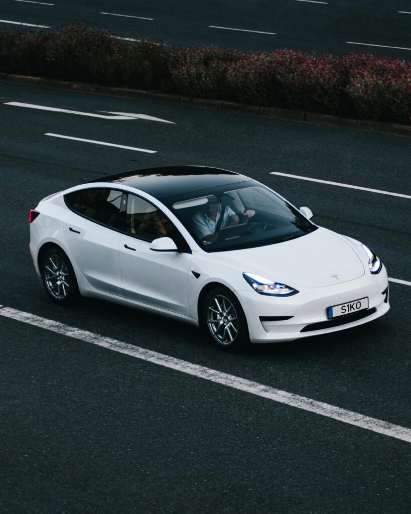 Tesla Model 3 driving on a highway in Osnabrück, Germany, showcasing modern electric vehicle design.